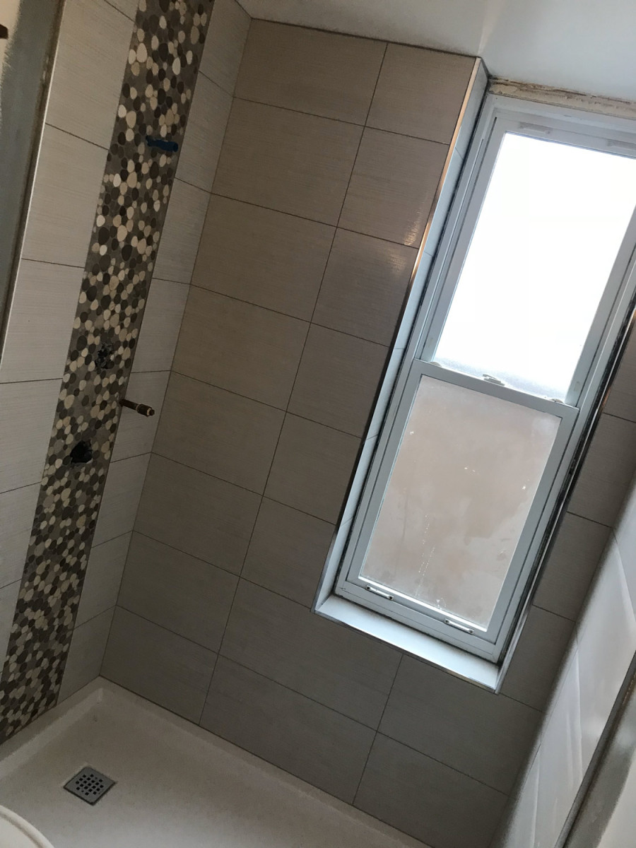 Bathroom with a walk-in shower featuring custom glass doors