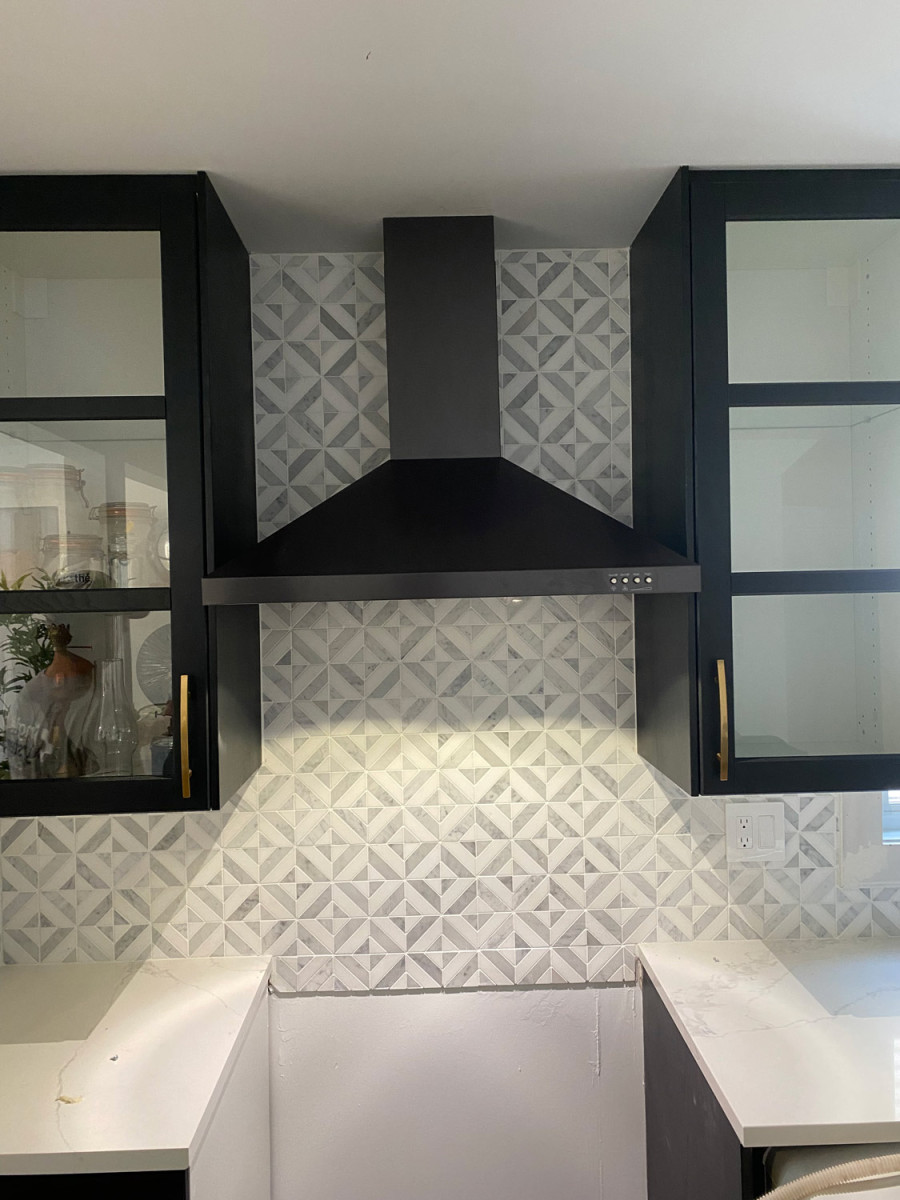 Kitchen with bold backsplash tiles and black matte fixtures