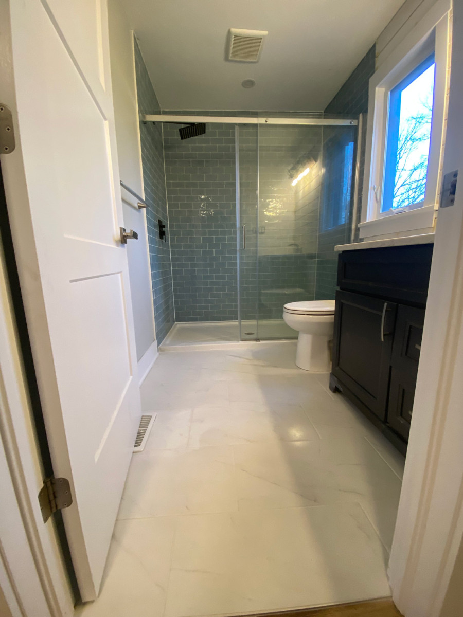 Bathroom featuring a hinged glass shower door and a sleek design