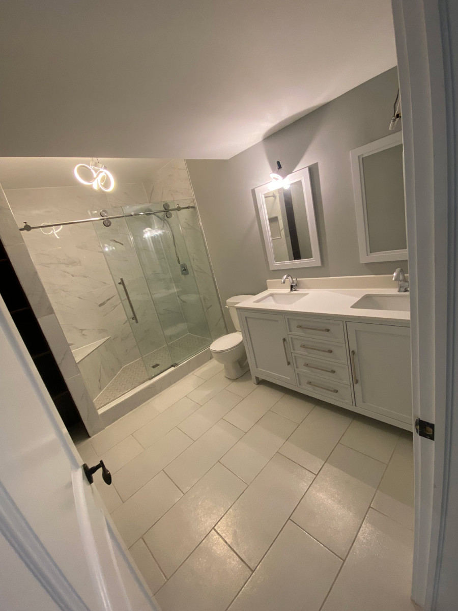 Bathroom with textured walls and a custom glass shower enclosure