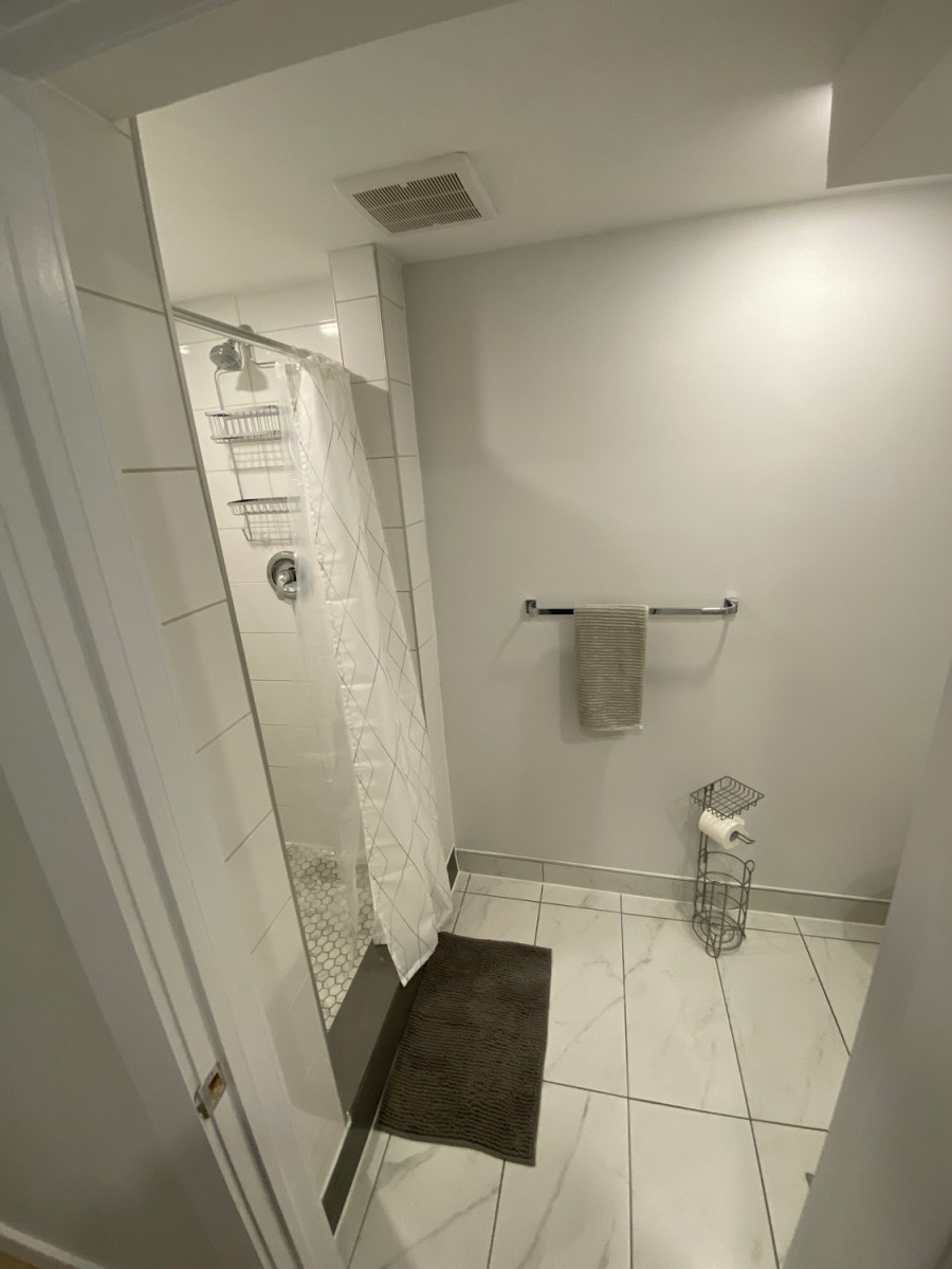 Bathroom with a walk-in shower featuring custom glass doors