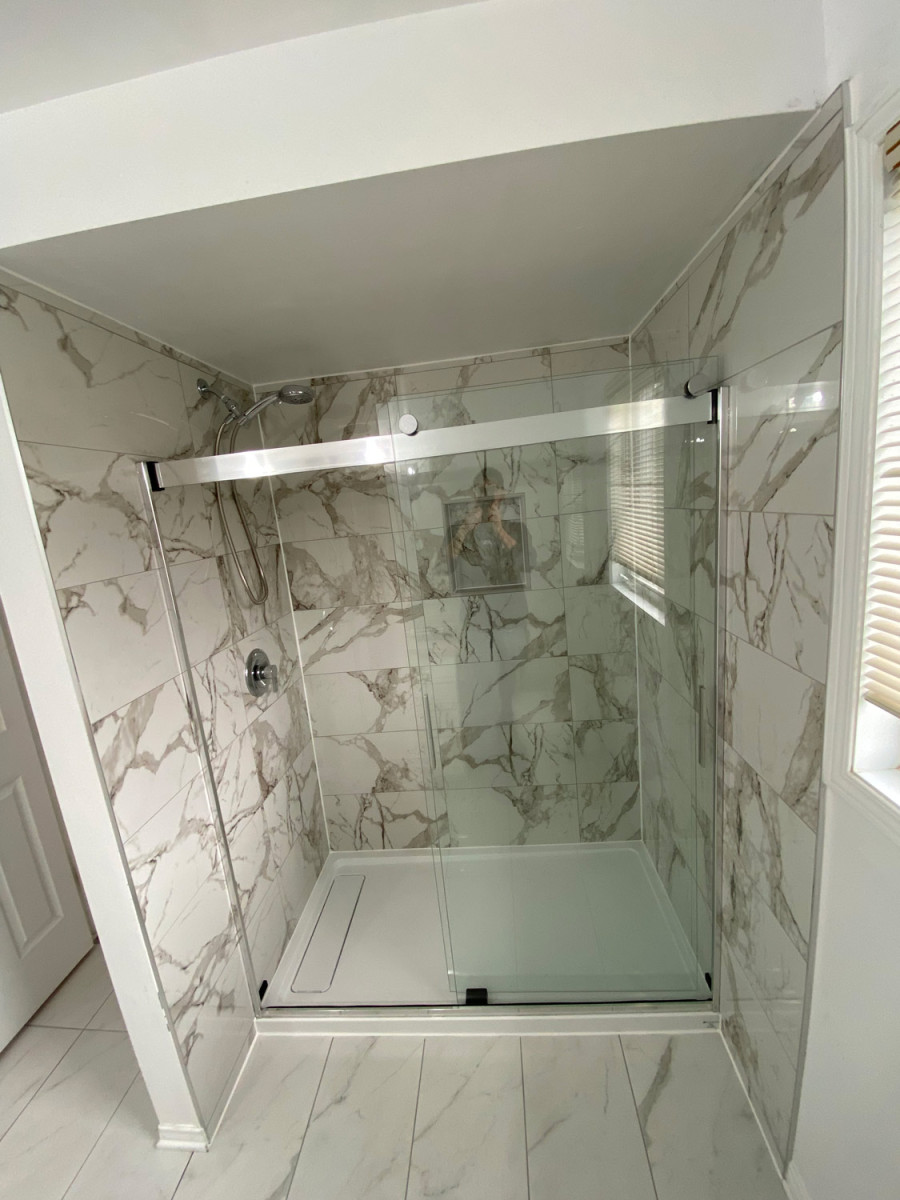 Sliding glass door in a compact bathroom with a walk-in shower