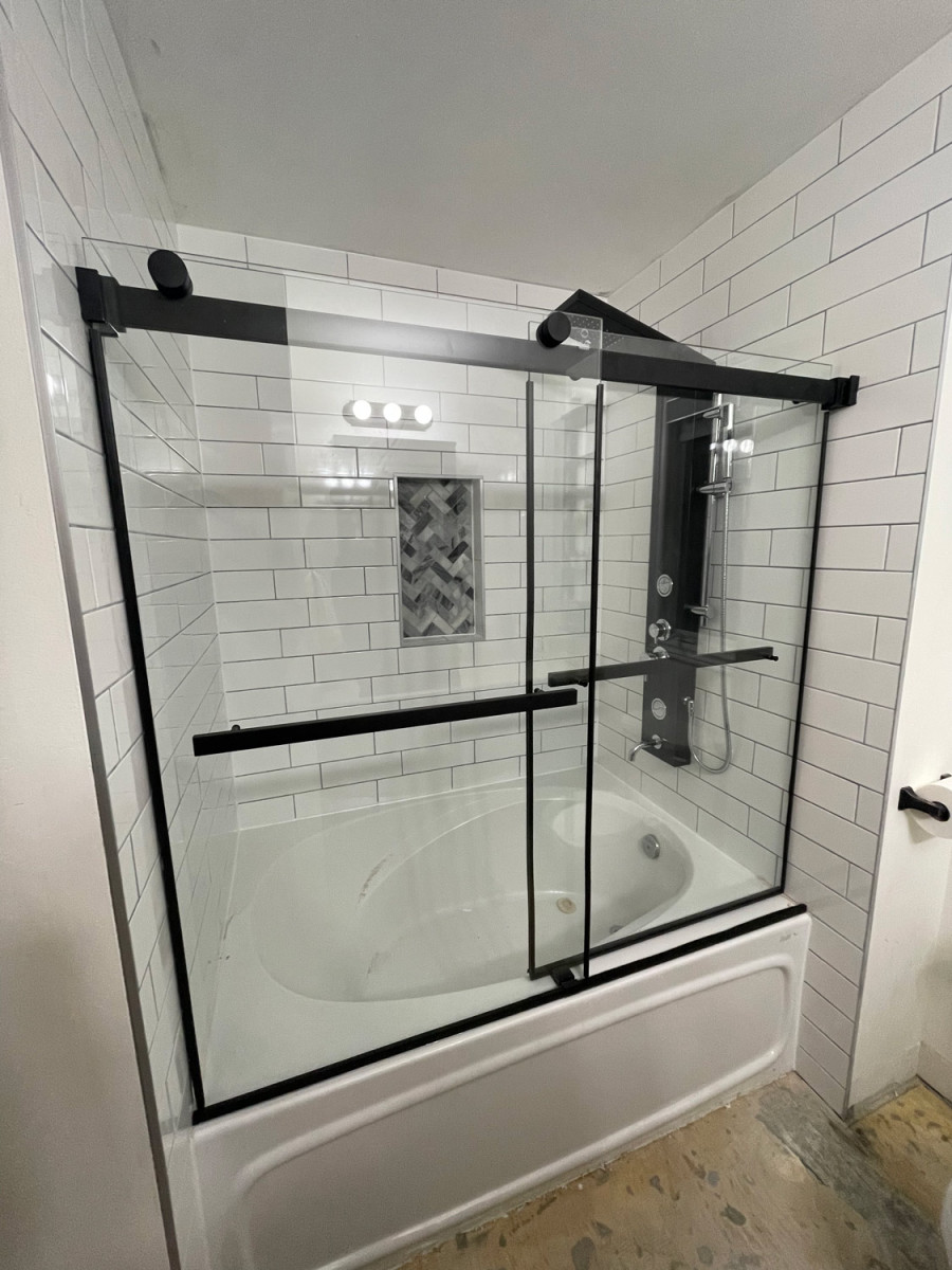 Bathroom with a walk-in shower featuring custom glass doors