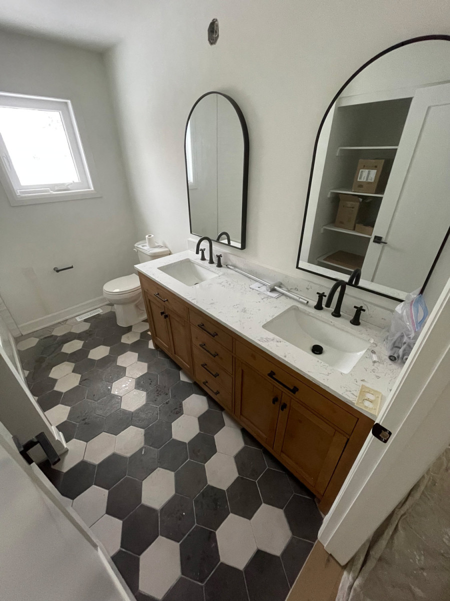 Round bathroom sink with a matte black faucet in a modern setup