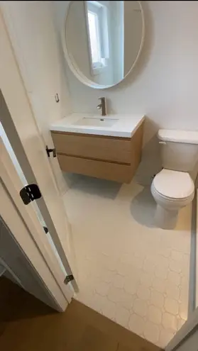 Bathroom with an oversized mirror and natural stone sink